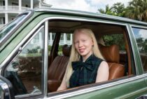 Портрет женщины-альбиноса в зелёном автомобиле — работа нейросети Flux