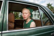 Портрет женщины-альбиноса в зелёном автомобиле — работа нейросети Flux